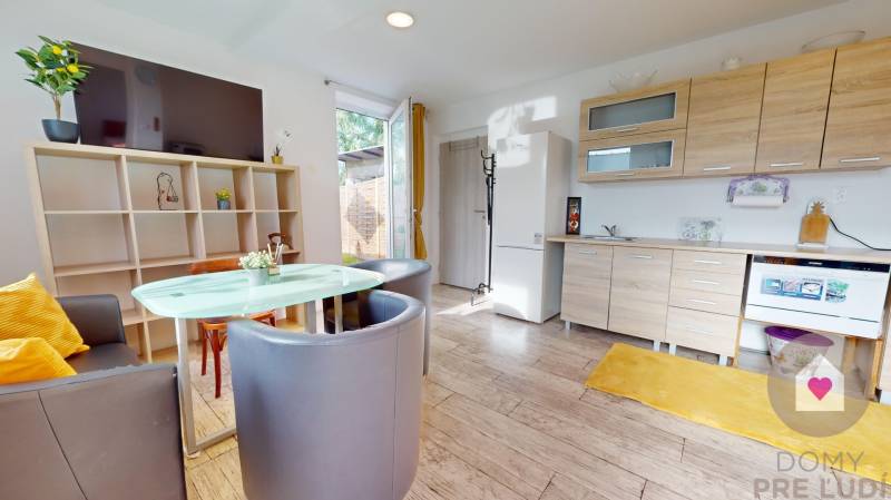 DOBROHOŠŤ- Prenájom  3i zariadeného bytu s predzáhradkou a parkingom - Interiér 3-izbového bytu s kuchynskou linkou, dreveným dekorom podlahy a jedálenským stolom.