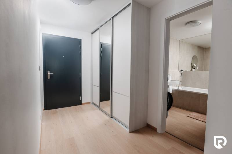 | E2Tower | 20.poschodie | 2i byt | panoramatický výhľad |  - Chodba v 2-izbovom byte s podlahou s dreveným dekorom a vstupom do kúpeľne.