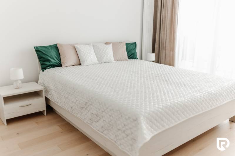 | E2Tower | 20.poschodie | 2i byt | panoramatický výhľad |  - Spálňa s pohodlnou posteľou, dekoračnými vankúšmi a nočným stolíkom v 2-izbovom byte.