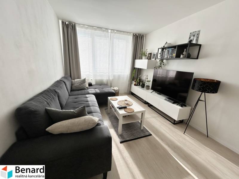 NA PREDAJ ŠTÝLOVÝ 2- IZBOVÝ BYT, 50m2, SÍDLISKO 2, PREŠOV - Obývačka v 2-izbovom byte s podlahou s dreveným dekorom a sedačkou.