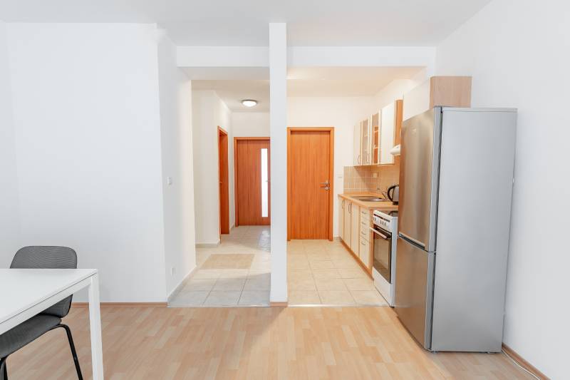 Luxusný 2-izbový byt + 2 balkóny, 73 m², garážové státie, Ružinov - Kuchyňa s jedálenským stolom v 2-izbovom byte, podlaha s dreveným dekorom.