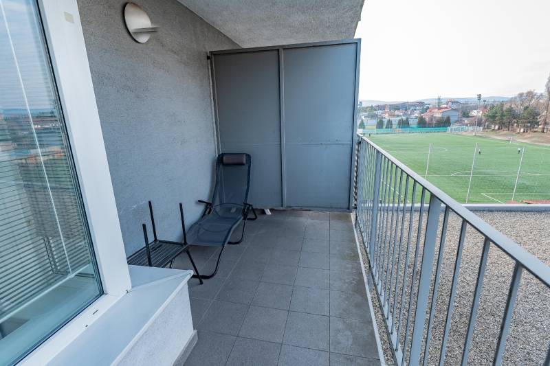 Luxusný 2-izbový byt + 2 balkóny, 73 m², garážové státie, Ružinov - Balkón 2-izbového bytu s výhľadom na futbalové ihrisko a ležadlom.