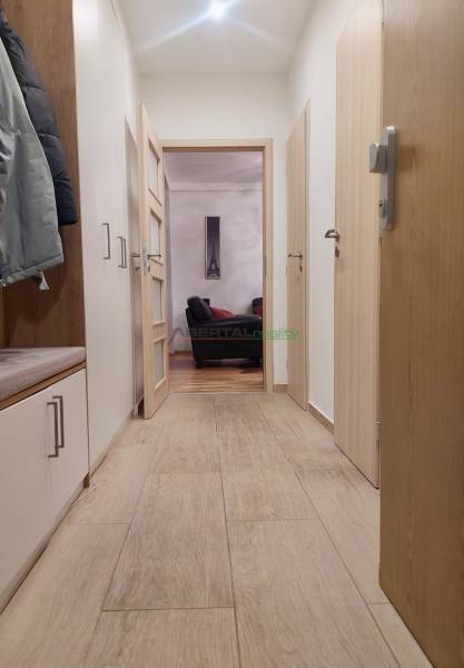 Vkusný, moderný 2 izb, klíma, 870 s ener., Sibírska ul./Nové Mesto - Chodba v 2-izbovom byte s podlahou s dreveným dekorom a pohľadom na obývačku.