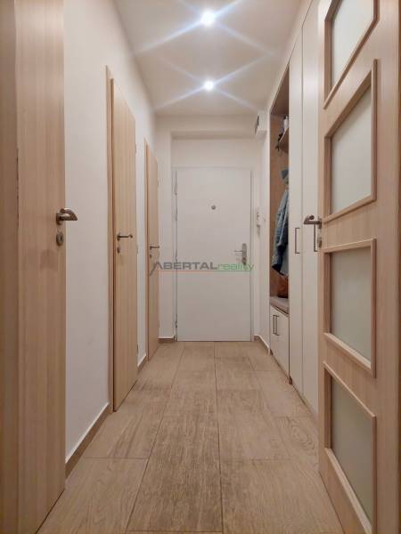 Vkusný, moderný 2 izb, klíma, 870 s ener., Sibírska ul./Nové Mesto - Chodba s podlahou s dreveným dekorom v 2-izbovom byte; biele dvere s úložným priestorom.