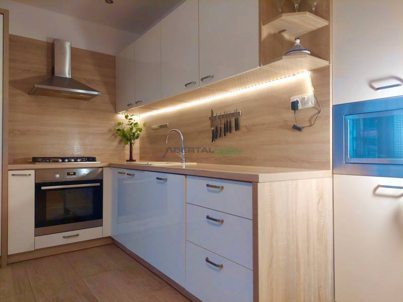 Vkusný, moderný 2 izb, klíma, 870 s ener., Sibírska ul./Nové Mesto - Kuchyňa v 2-izbovom byte s podlahou s dreveným dekorom a vstavanými spotrebičmi.