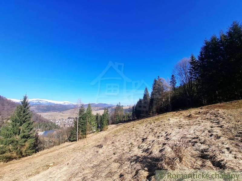 Veľký pozemok na čarovnom mieste polosamota Hronec 2. - Kopcovitá krajina poľnohospodárskych a lesných pozemkov okolo obce Hronec so zimnou panorámou.