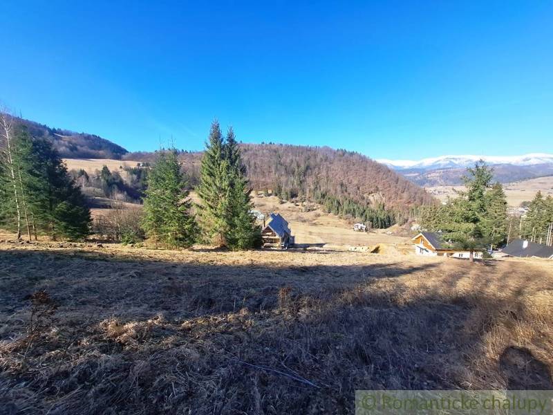Veľký pozemok na čarovnom mieste polosamota Hronec 2. - Poľnohospodárske a lesné pozemky v Hronci, obklopené kopcami a ihličnatými stromami.