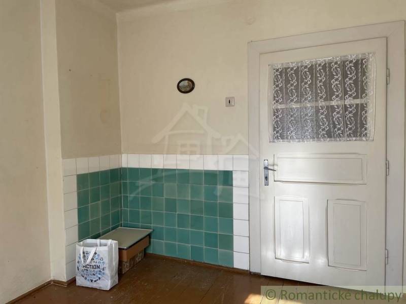 Vidiecky dom v gemerskej obci Bretka - Interiér rodinného domu s bielymi dverami a zeleno-bielymi obkladačkami na stenách.