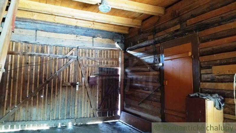 Pôvodná goralská drevenica, Osturňa - Interiér dreveného rodinného domu s drevenou bránou a osvetlením.