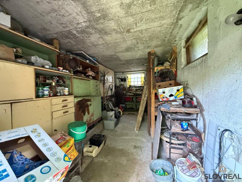 Predaj domu v Janovej Lehote - Kotoľňa s regálmi a nástrojmi v rodinnom dome, úložné priestory plné rôznych predmetov.