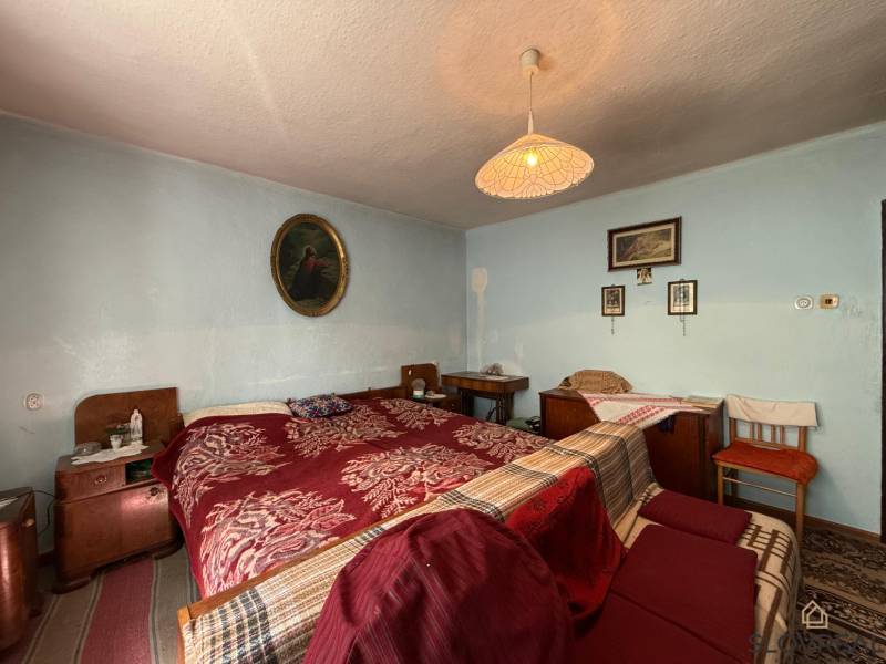 Predaj domu v Janovej Lehote - Spálňa v rodinnom dome so starožitným nábytkom a umeleckými obrazmi.