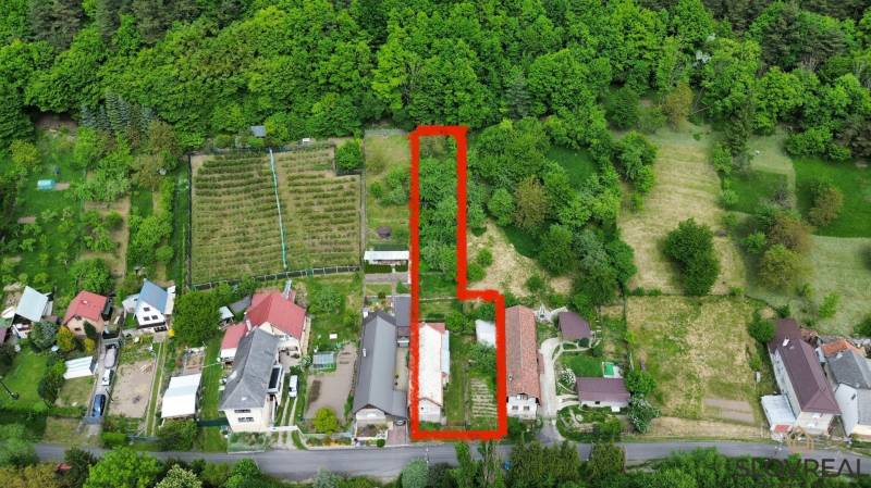 Predaj domu v Janovej Lehote - Letecký pohľad na záhradné pozemky a rodinné domy v Janovej Lehote obklopené zeleňou.