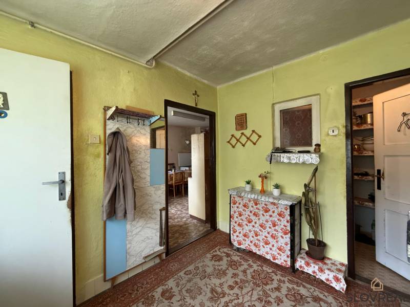 Predaj domu v Janovej Lehote - Chodba v rodinnom dome s vešiakom, zrkadlom a dekoráciami, farebné steny.