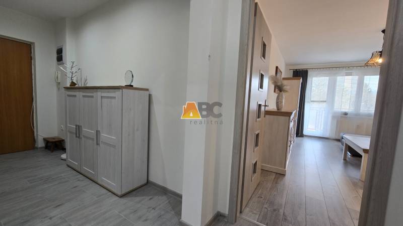 Moderný 2-izbový byt po rekonštrukcii v srdci Zlatého potoka - Zvolen - Vstupná hala a obývačka v 2-izbovom byte s podlahou s dreveným dekorom.