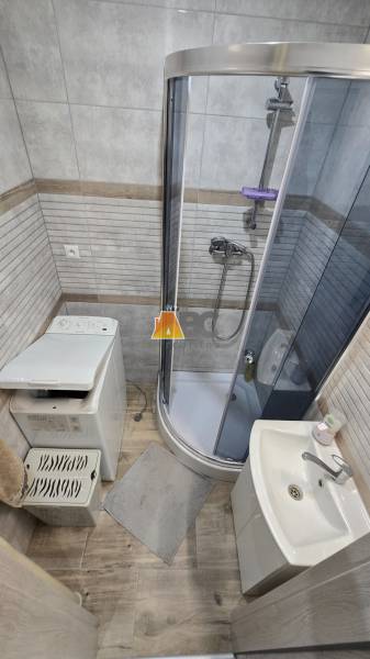 Moderný 2-izbový byt po rekonštrukcii v srdci Zlatého potoka - Zvolen - Kúpeľňa so sprchovým kútom a umývadlom v 2-izbovom byte, podlaha s dreveným dekorom.