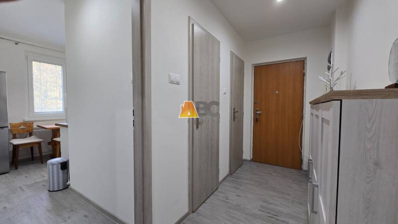 Moderný 2-izbový byt po rekonštrukcii v srdci Zlatého potoka - Zvolen - Vstupná predsieň s drevenými dverami a nábytkom v 2-izbovom byte, svetlá podlaha.