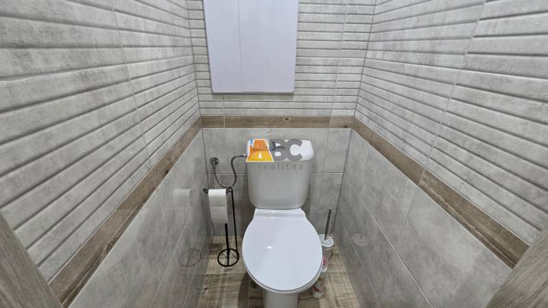 Moderný 2-izbový byt po rekonštrukcii v srdci Zlatého potoka - Zvolen - Kúpeľňa z 2-izbového bytu s toaletou a podlahou s dreveným dekorom.