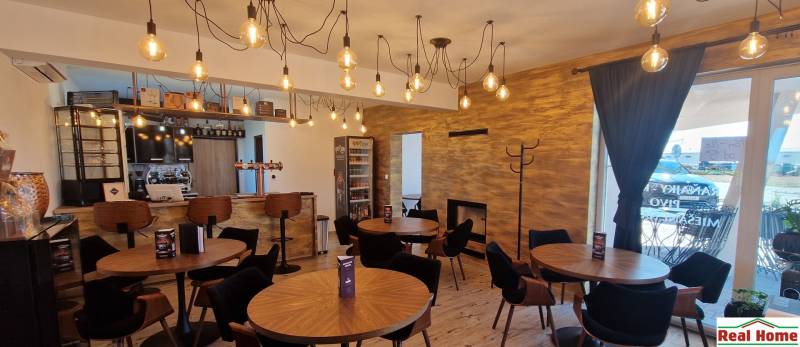 Prenájom kaviarne  v obci Nová Dedinka pri Senci - Gastro priestory s visiacimi svetlami, dreveným dekorom a útulným sedením.