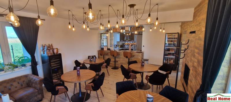 Prenájom kaviarne  v obci Nová Dedinka pri Senci - Interiér gastro priestorov s podlahou s dreveným dekorom a osvetlením žiarovkami.