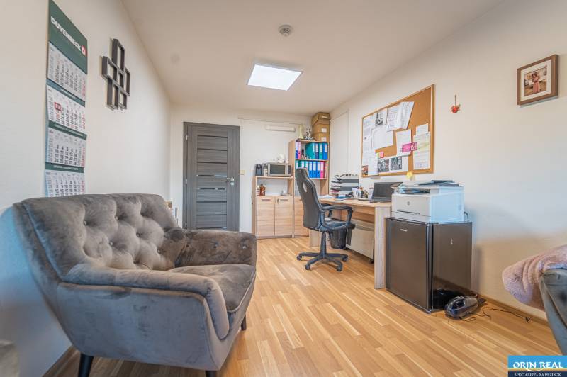 MODERNÝ KANCELÁRSKY PRIESTOR NA PRENÁJOM - Kancelária s podlahou s dreveným dekorom, pohodlným kreslom a pracovným stolom.