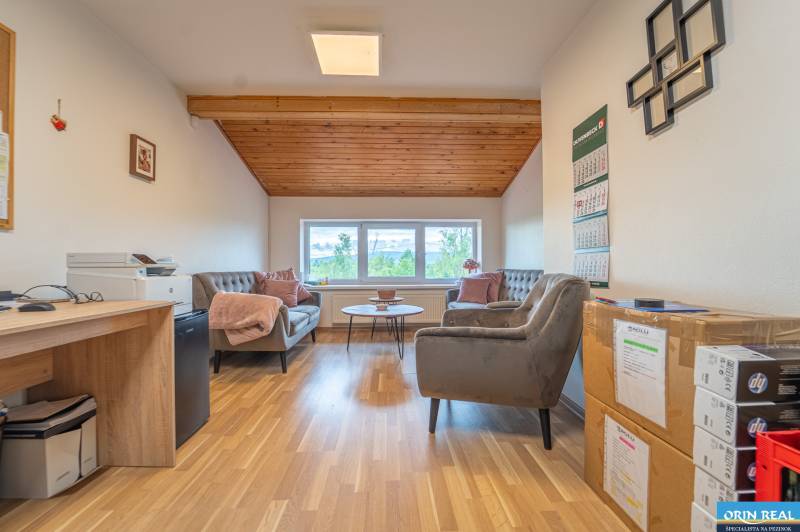 MODERNÝ KANCELÁRSKY PRIESTOR NA PRENÁJOM - Kancelárie s podlahou s dreveným dekorom, pohovkou, kreslami a pracovným stolom.