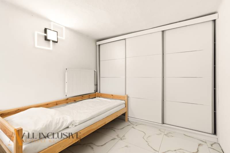 NADŠTANDARDNÁ REKREAČNÁ CHATA | DUCHONKA  - Jednolôžková posteľ s bielou posteľnou bielizňou, moderná svietidlá a veľká šatníková skriňa v Chate.