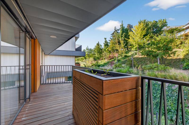 ︱ PREDAJ Nadštandardný 3-izb. byt v projekte Gansberg Koliba - Balkón s podlahou s dreveným dekorom, s výhľadom na zeleň v 3-izbovom byte.