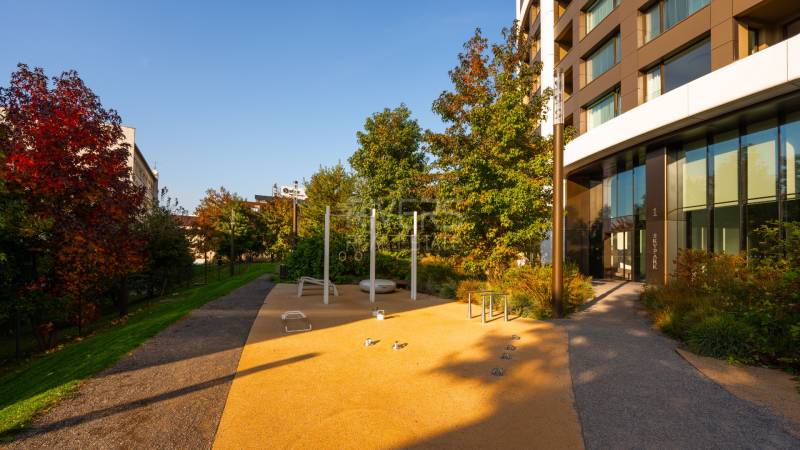 Elegantný byt na mieru s panorámou hradu  - Exteriérna časť s workoutovou zónou a zeleňou pri bytovom dome na Čulenovej ulici.