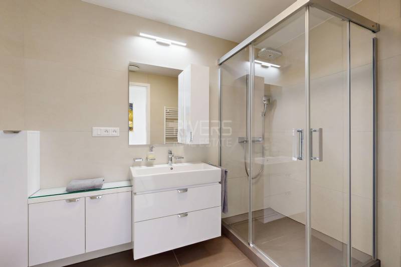 Elegantný byt na mieru s panorámou hradu  - Kúpeľňa v 3-izbovom byte so sprchovacím kútom, umývadlom a úložnými skrinkami.