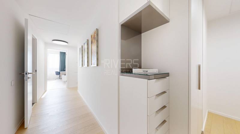 Elegantný byt na mieru s panorámou hradu  - Svetlá chodba s podlahou s dreveným dekorom a bielym nábytkom v 3-izbovom byte.