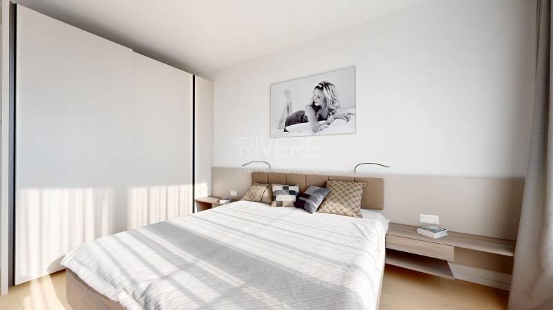 Elegantný byt na mieru s panorámou hradu  - Spálňa v 3-izbovom byte s veľkou posteľou, podlahou s dreveným dekorom, obrazom a skriňou.