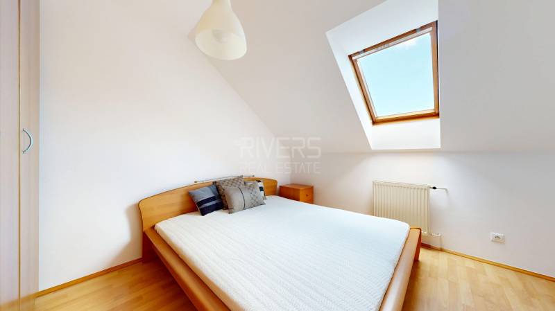 RIVERS - Veľkorysý rodinný dom po rekonštrukcii  - Spálňa s manželskou posteľou, strešným oknom a podlahou s dreveným dekorom v rodinnom dome.