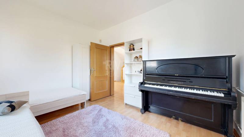 RIVERS - Veľkorysý rodinný dom po rekonštrukcii  - Izba v rodinnom dome s klavírom, posteľou, policovou skriňou a podlahou s dreveným dekorom.