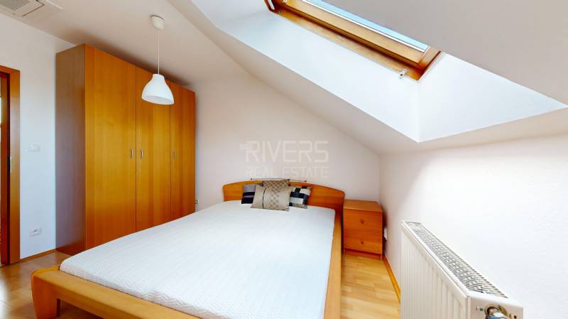 RIVERS - Veľkorysý rodinný dom po rekonštrukcii  - Spálňa v rodinnom dome s posteľou, strešným oknom a podlahou s dreveným dekorom.