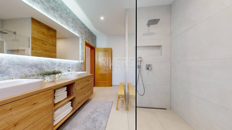 RIVERS - Veľkorysý rodinný dom po rekonštrukcii  - Kúpeľňa v rodinnom dome s umývadlami, sprchou a skrinkou s dreveným dekorom.