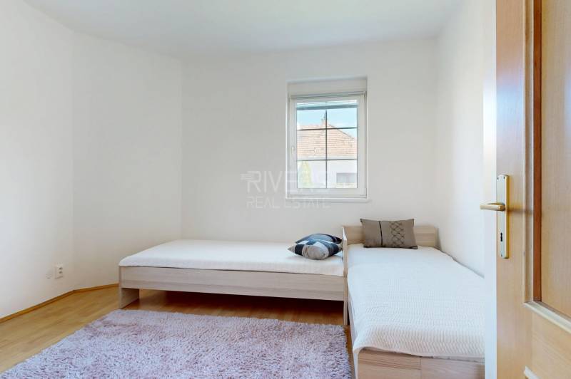 RIVERS - Veľkorysý rodinný dom po rekonštrukcii  - Svetlá izba v rodinnom dome s dvomi jednolôžkami a podlahou s dreveným dekorom.