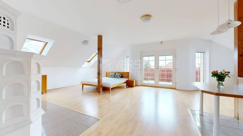 RIVERS - Veľkorysý rodinný dom po rekonštrukcii  - Interiér rodinného domu s krbovými kachľami, posteľou a podlahou s dreveným dekorom.