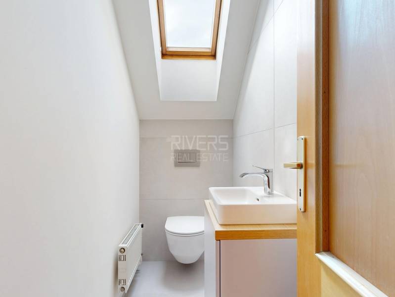 RIVERS - Veľkorysý rodinný dom po rekonštrukcii  - Kúpeľňa v podkroví rodinného domu so strešným oknom a umývadlom.