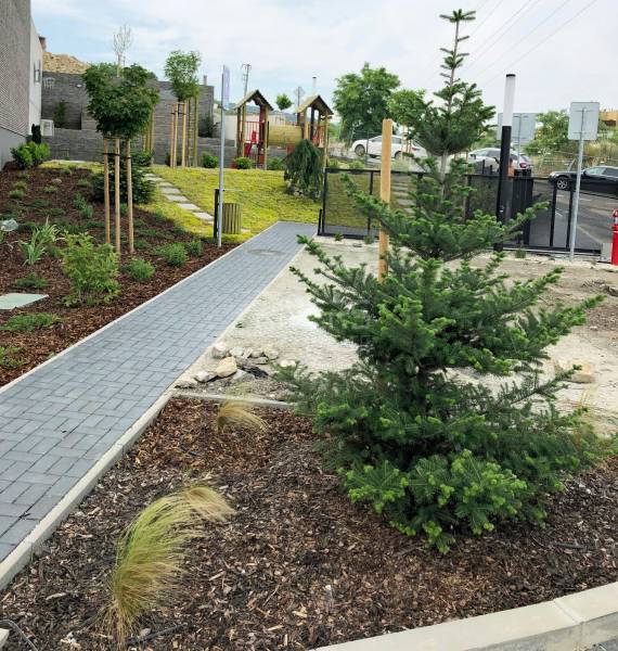 RIVERS I Prémiový 4-izbový byt s panoramatickým výhľadom na mesto - Záhrada s vysadeným stromom a chodníkom v okolí Bratislavy - Nového Mesta na ulici Na Roličkách.