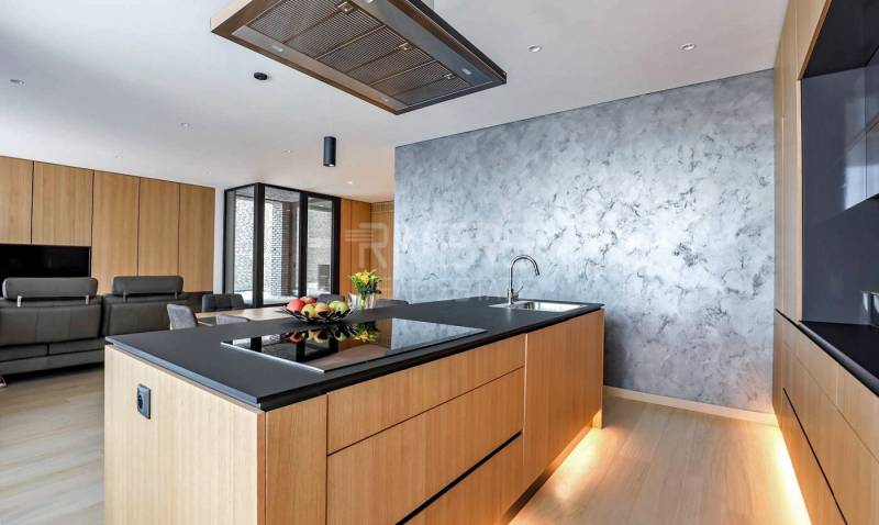 RIVERS I Prémiový 4-izbový byt s panoramatickým výhľadom na mesto - Kuchyňa v 4-izbovom byte s podlahou s dreveným dekorom a jedálenským kútom.