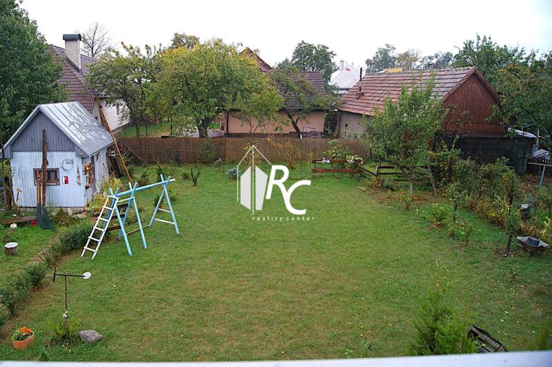 Zrekonštruovaný rodinný dom s peknou záhradou, Bystrička - Záhrada s trávnikom a drevenou stavbou pri rodinnom dome v Bystričke.