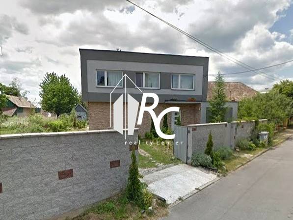 Zrekonštruovaný rodinný dom s peknou záhradou, Bystrička - Rodinný dom v Bystričke s upravenou záhradou a vysokým plotom pozdĺž ulice.