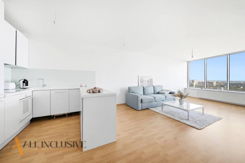 Na predaj luxusný 2-izb. byt s loggiou v Bratislave  - Útulná kuchyňa s bielymi skrinkami, sedačkou a veľkou presklenou stenou v 2-izbovom byte.