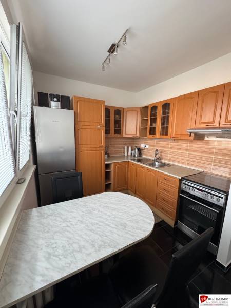 Prenájom 2-izb bytu v Bratislave-Rača - Kuchyňa v 2-izbovom byte s drevenými skrinkami a mramorovým stolom.