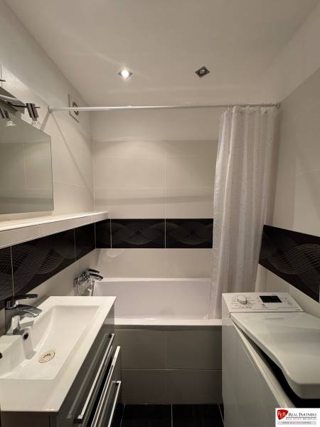 Prenájom 2-izb bytu v Bratislave-Rača - Kúpeľňa v 2-izbovom byte s vaňou, umývadlom a práčkou, decentné obklady.