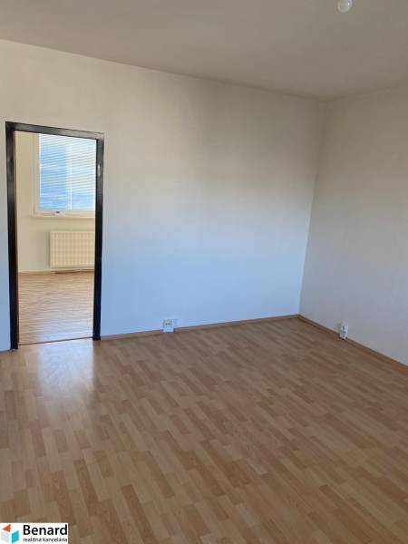 3 - IZBOVÝ BYT NA SÍDLISKU ZÁPAD Stará Ľubovňa - Izba v 3-izbovom byte s bielymi stenami a podlahou s dreveným dekorom.