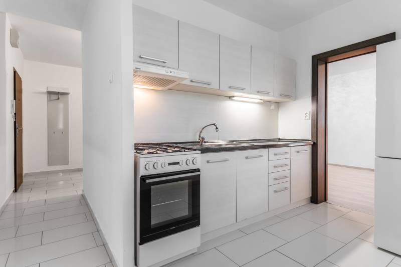 I Predaj 3- izbového bytu v Dúbravke - Kuchyňa s bielymi skrinkami a sporákom v 3-izbovom byte.