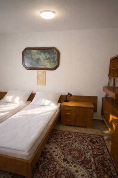 Bývajte vo svojom : dom a  pozemok 690 m², Veľké Ripňany 77.000,-EUR - Spálňa v rodinnom dome s dvomi posteľami, nočným stolíkom a obrazom na stene.