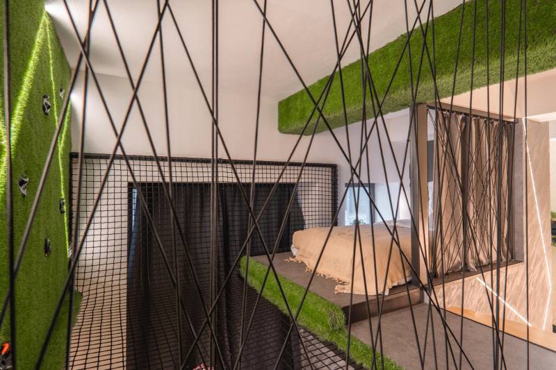 | Luxusný dvojúrovňový mezonet v Starom Meste - Spálňa v 3-izbovom byte s horolezeckou stenou a sieťou, dekorovaná umelým trávnikom.