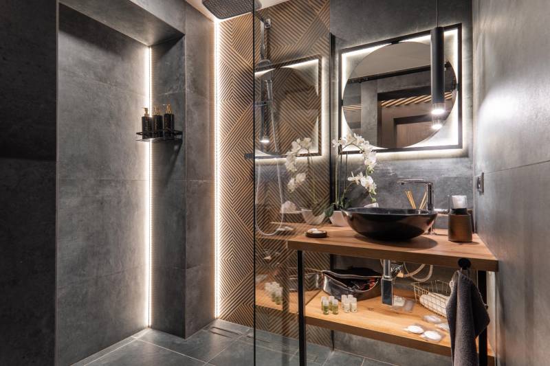 | Luxusný dvojúrovňový mezonet v Starom Meste - Kúpeľňa v 3-izbovom byte s luxusným dizajnom, osvetlením a dreveným nábytkom.